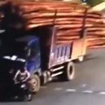 木材を積んだトラックが転倒。その下敷きとなる男性の動画。