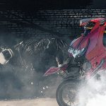 2人乗りバイクがウィリーして転倒 → バスに轢かれて死亡。