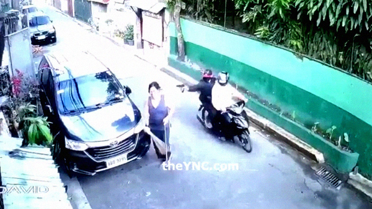 後ろから来たバイクの男に頭を撃たれて殺される女性。