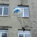 猫にパラシュートをつけて窓から放り投げて遊ぶ男たち。