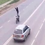 バイクを運転中に座席に立ってアクロバティックな技を披露した男、事故る。