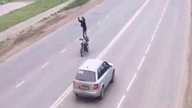 バイクを運転中に座席に立ってアクロバティックな技を披露した男、事故る。