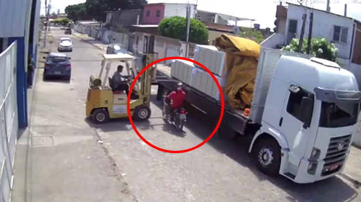 トラックに荷物を積んでいたフォークリフトの隙間を通ろうとしたバイク、転倒してしまう･･･。