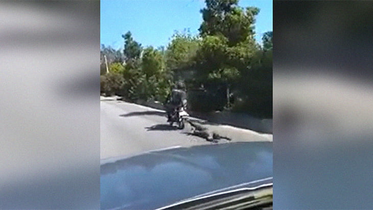 バイクにロープで繋がれ道路を引きずり回される男。