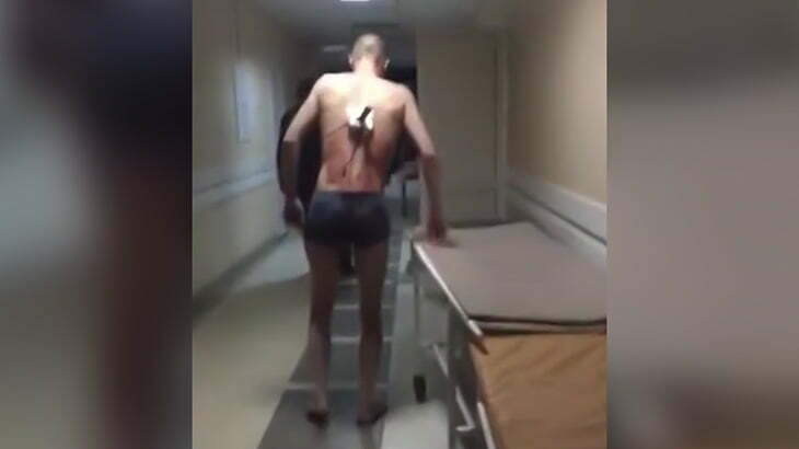 背中にナイフが刺さった状態で何故か病院内を歩き回る男の映像。