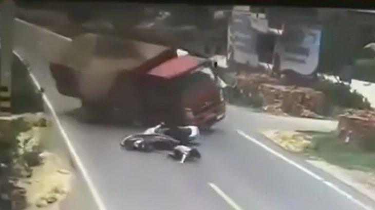 バイク同士の謎の接触事故によりトラックが横転して下敷きになったバイカーが死亡する映像。