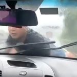 ボンネットに男を乗せたまま高速道路を走る車の?像。