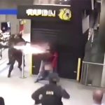 女性を人質にとった男の背後から近づいて銃で撃つ警察官の映像。