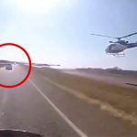 逃走する車を警察のバイクとヘリが追跡する映像。