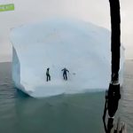 巨大な流氷が動き出して2人の男性が海に落下してしまう映像。