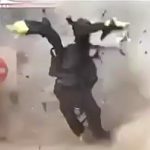 防護服を着た爆弾処理の男性が吹き飛ばされる映像。