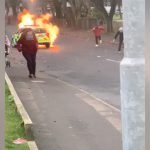 警察車両に火炎瓶を投げつけて走り去る男たちの映像。