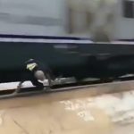通過する電車ギリギリのところでスケボーする男たちの映像。