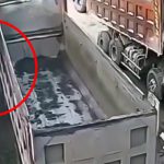 トラックにゆっくり挟まれてしまう男の映像。