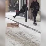 凍った歩道で転倒する人たちを見て大爆笑する男たちの映像。