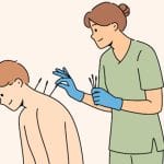 患者の肩や足に鍼（はり）を刺してツボを刺激する鍼灸師のお仕事